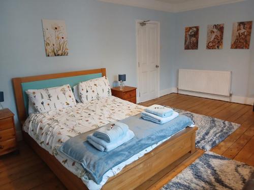 a bedroom with a bed with towels on it at Spacious 4 Bedroom House, Garden, Nr Ipswich Town Centre with hot tub in Ipswich