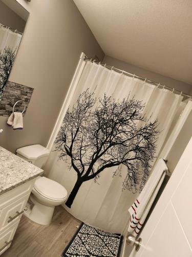 a bathroom with a shower curtain with a tree on it at Federal Palace in Saskatoon