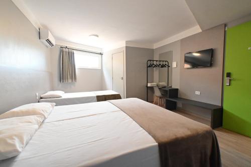 pokój hotelowy z dwoma łóżkami i zieloną ścianą w obiekcie Hotel PrimeInn Excelente Custo Benefício e Taxas de Estacionamento Isentas w mieście Campinas