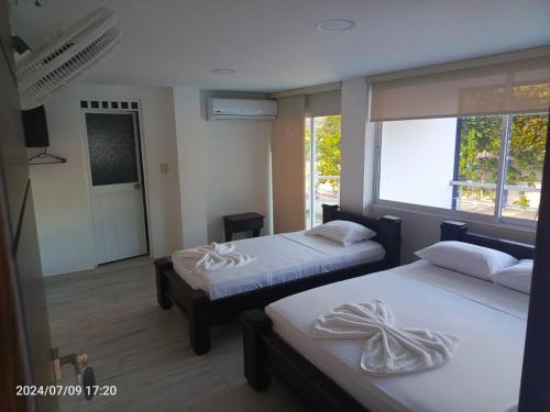 a room with two beds and a window and a window at Hotel Perla Dorada in San Miguel