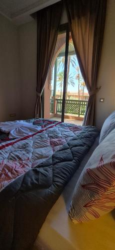 a bed in a bedroom with a window at Chic Palm Grove Apartment Pool View in Marrakesh