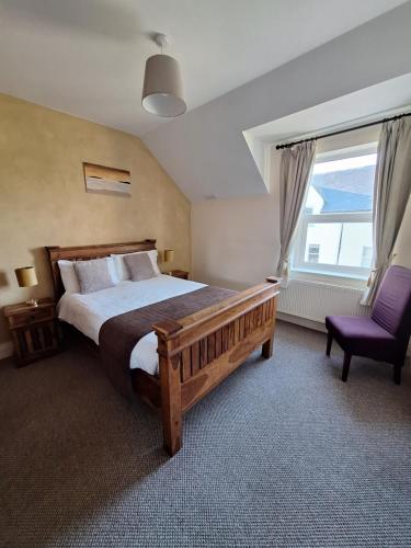 a bedroom with a large bed and a purple chair at Doolin Court in Doolin