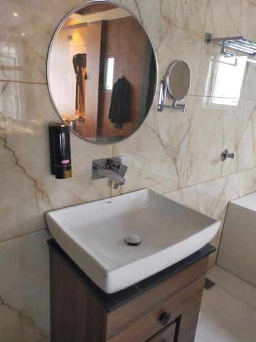 a bathroom with a white sink and a mirror at Pine Breeze Luxe in Gulmarg