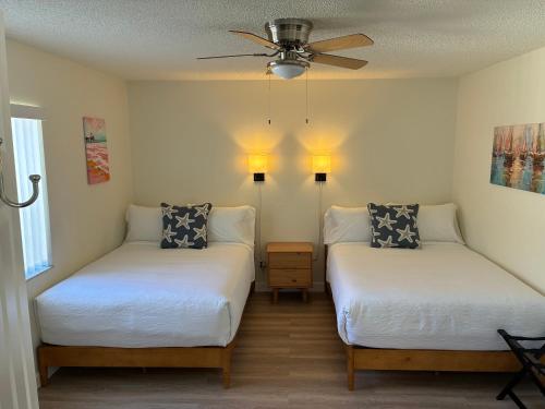 a bedroom with two beds and a ceiling fan at Sea Breeze Inn in Edgewater