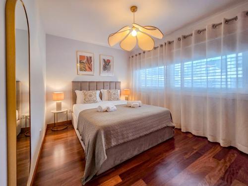 a bedroom with a bed and a large window at Sweet Living Viana - City Centre Apartment with Garage in Viana do Castelo