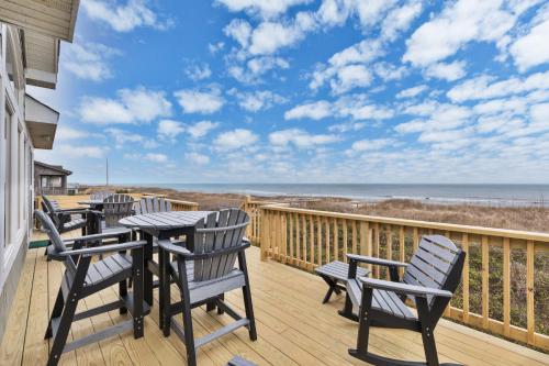 a deck with chairs and a table with a view of the ocean at 2440 - Solitude South in Duck