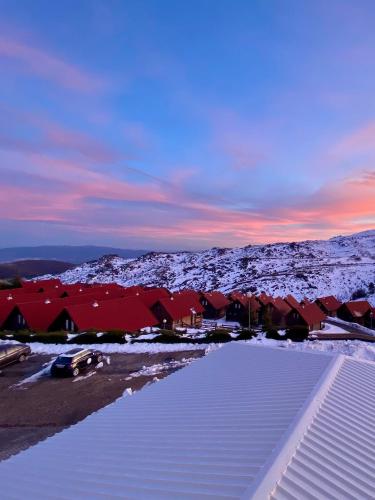 a group of houses with snow on the roofs at EntreVales Serra da Estrela in Penhas da Saúde
