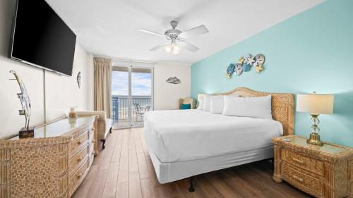 a bedroom with a white bed and a television at Romar Tower 5C in Romar Beach