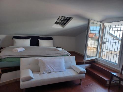 a bedroom with a large bed and a white couch at Hotel Villa Pagoda in Sirmione