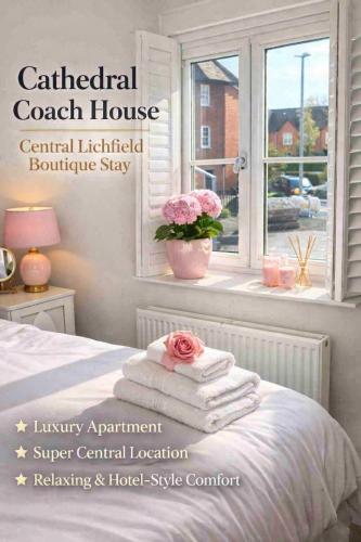a room with a bed with towels and a window at Cathedral Coach House - Lichfield in Lichfield