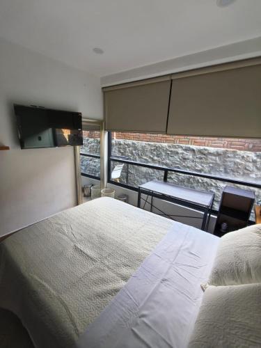 a bedroom with a bed and a view of a building at Downtown Historic Area Modern and Comfortable in Puebla
