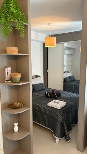 a bedroom with a bed and a book shelf at Studio completo com charme em ótima localização! in Juiz de Fora