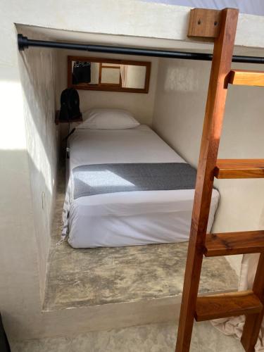 a bedroom with two bunk beds and a ladder at Frequency Hostel beachfront in El Cuyo