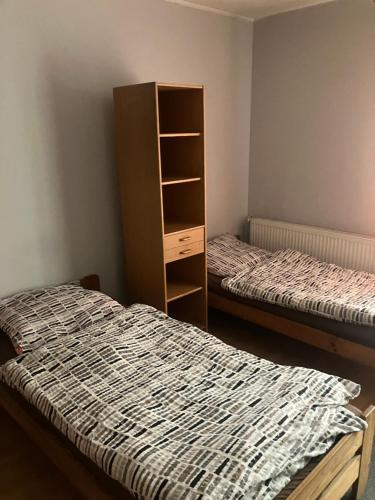 a bedroom with two beds and a book shelf at Noclegi Ściegiennego in Sosnowiec