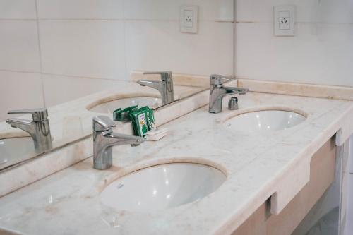 two sinks in a bathroom with two faucets at La Regina Lodge in Itatí