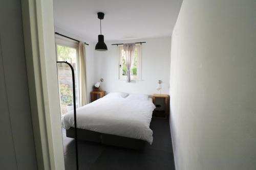 ein Schlafzimmer mit einem weißen Bett und einem Fenster in der Unterkunft Bed & Breakfast Zeeland in Renesse