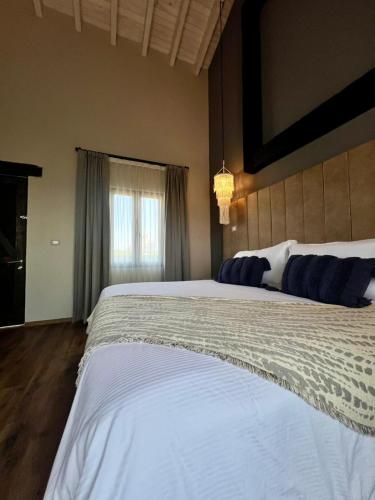 ein großes weißes Bett in einem Schlafzimmer mit Fenster in der Unterkunft Suites Campestres Montebello in Bernal
