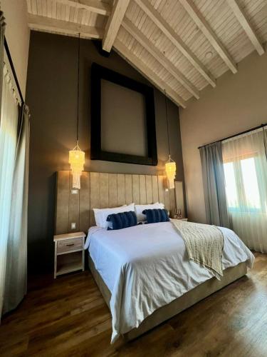 ein Schlafzimmer mit einem großen weißen Bett und einem Fenster in der Unterkunft Suites Campestres Montebello in Bernal
