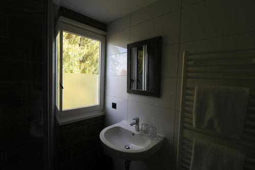 ein Badezimmer mit Waschbecken und Fenster in der Unterkunft Bed & Breakfast Zeeland in Renesse