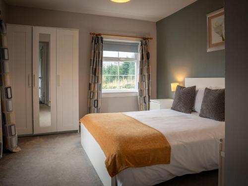 a bedroom with a large bed and a window at The Bothy in Blairgowrie