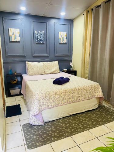 a bedroom with a large bed with blue walls at Sunzal Bungalow Aloha in El Sunzal