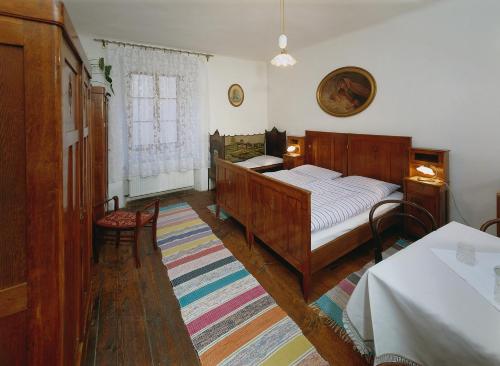 a bedroom with a wooden bed and a rug at Penzion Na Louži in Český Krumlov