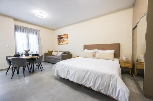 a bedroom with a bed and a table and a couch at Antheon Suites Volos in Volos