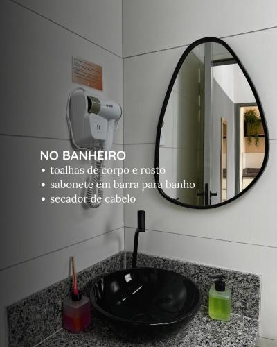 a bathroom with a sink and a mirror at Loft Oriente - 800m do Parque das Águas in São Lourenço