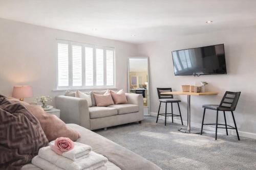 a living room with a couch and a table at Cathedral Coach House - Lichfield in Lichfield