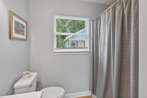 a bathroom with a toilet and a window at Gil's Bayou Cabins in Ocean Springs