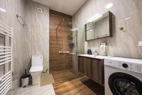 a bathroom with a sink and a washing machine at Antheon Suites Volos in Volos
