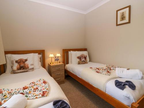 two twin beds in a room with two lamps at 48 Edenbank Road in Cupar