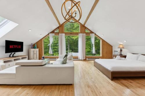 a large bedroom with two beds and a large window at Modern Cottage Laurentians Private Pool & Nature in Brownsburg