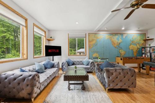 a living room with couches and a map on the wall at Modern Cottage Laurentians Private Pool & Nature in Brownsburg