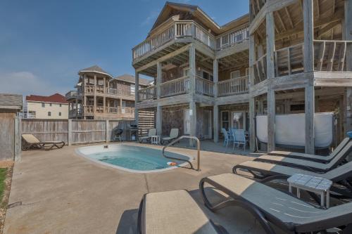a large house with a pool and patio furniture at 5468 - Mermaids' Lagoon in Nags Head