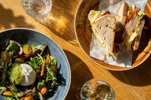 a table with two plates of food and a sandwich and salad at The Social Hub Groningen in Groningen