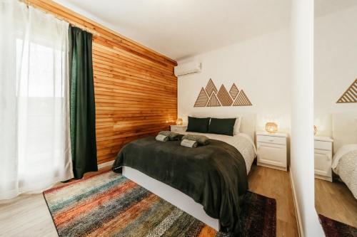 a bedroom with a bed and a wooden wall at EntreVales Serra da Estrela in Penhas da Saúde