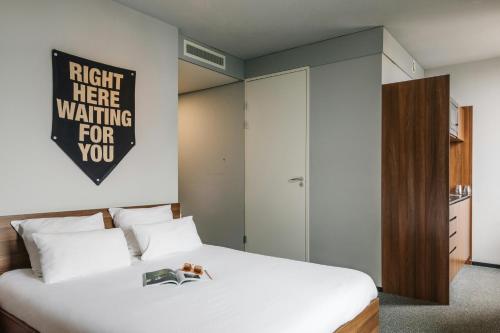 a bedroom with a bed with a sign on the wall at The Social Hub Eindhoven in Eindhoven