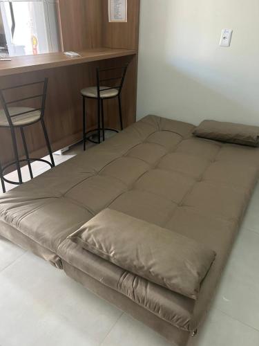 a large bed in a room with a table and chairs at Studio J&C 01 in Primavera do Leste
