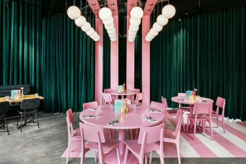 a dining room with pink tables and pink chairs at The Social Hub Groningen in Groningen