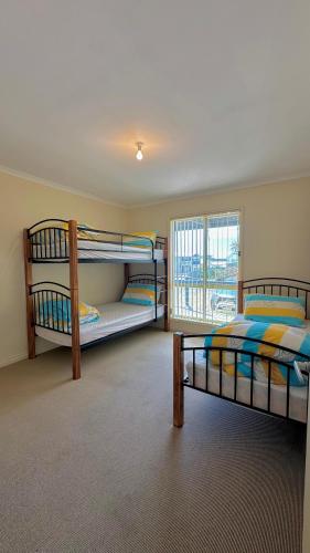 a bedroom with two bunk beds and a window at Catch N Relax in Point Turton