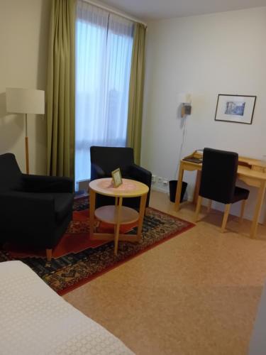 a living room with two chairs and a table at Birgittaklosteret i Trondheim in Trondheim