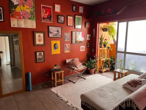a bedroom with an orange wall with a bed and a chair at Ap decorado Setor Bueno in Água Boa