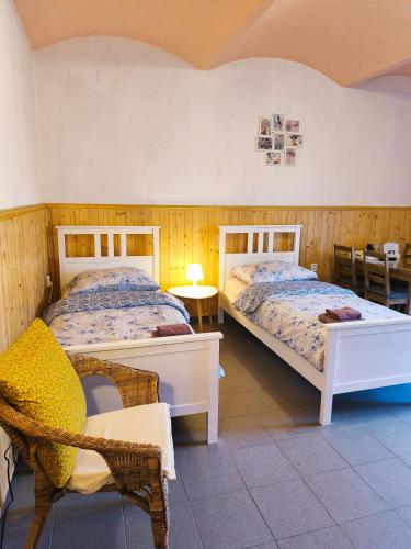 a bedroom with two beds and a chair at Ubytování U Tajčů in Dolní Beřkovice