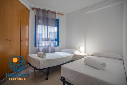 a bedroom with two beds and a window at Holiday Apartment Patacona Beach in Valencia