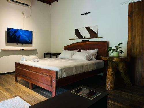 a bedroom with a bed and a tv on the wall at Zov Wild Yala in Kataragama