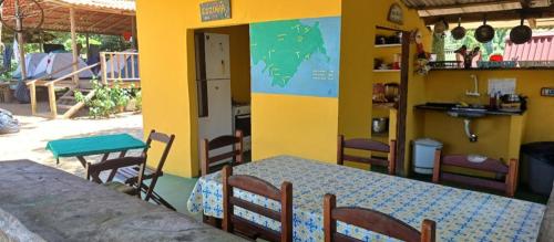 a dining room with a table and chairs in a room at Cabana 2 Camping Dona Aurora Praia do Sono in Paraty
