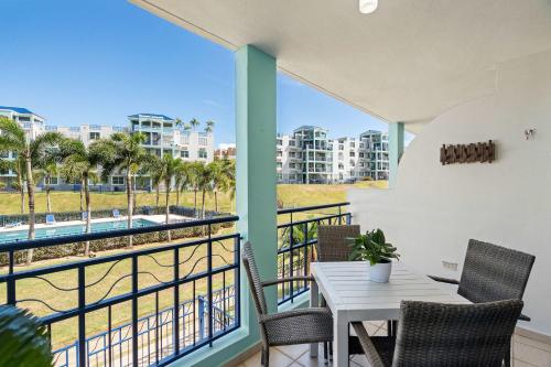 a balcony with a table and chairs and a view of the beach at Costa Brava Condo by Otium in Ceiba
