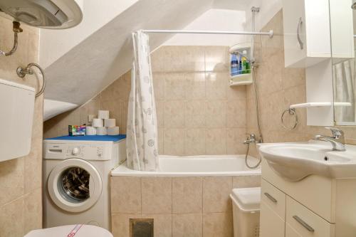 a bathroom with a washing machine and a sink at Old Town Boskovic Apartment in Kotor
