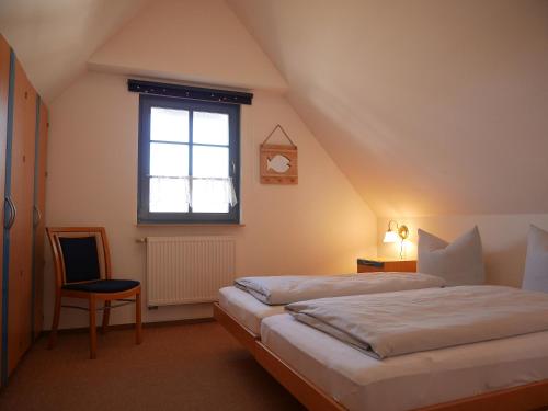 a attic bedroom with two beds and a window at Fini in Am Schwarzen Busch